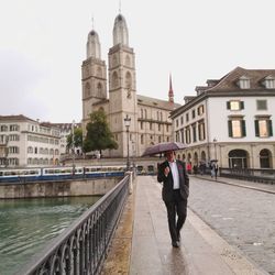 Full length of man amidst buildings against sky in city