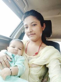 Portrait of cute baby girl in car