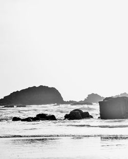 Rocks on beach against clear sky