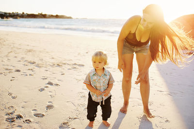 Mother and son standing on beach
