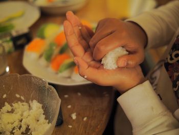 Cropped image of hands making sushi at home