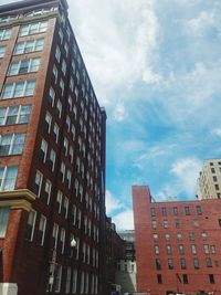 Low angle view of buildings against cloudy sky