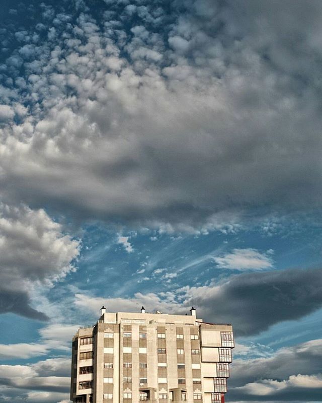 building exterior, architecture, built structure, low angle view, sky, cloud - sky, cloudy, building, cloud, high section, window, city, outdoors, residential structure, residential building, day, no people, house, overcast, weather