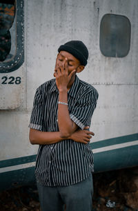 Full length of young man standing against wall