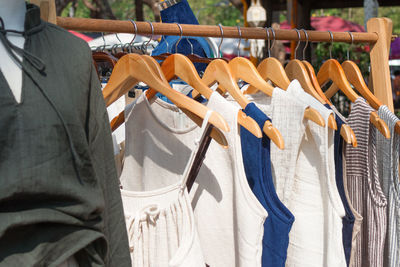 Clothes racks with cotton sundresses on hangers. showcase with clothes on street market.