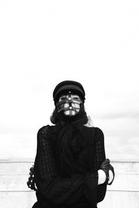 Portrait of woman wearing mask against wall