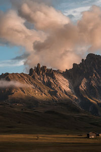 Scenic view of mountains and a small cabin in the valley at sunset in italy