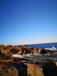 Scenic view of beach against clear blue sky