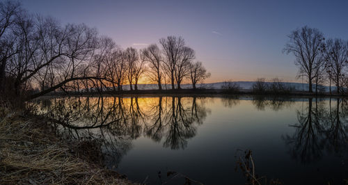 Scenic view of lake against sky at sunset