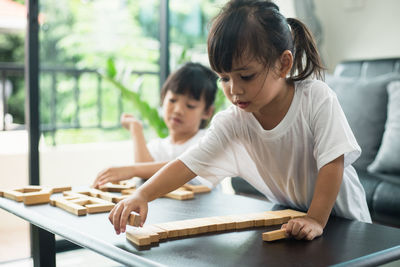 Girl looking at while sitting on table