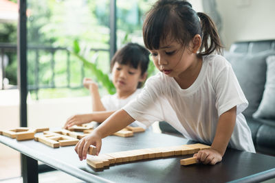 Girl looking at while sitting on table