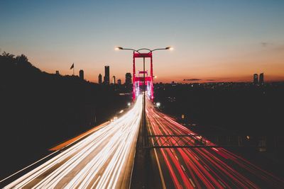 Light trails on road against sky at night