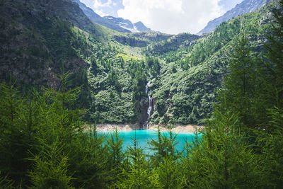 Scenic view of lake by mountains against sky