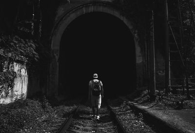 Rear view of woman walking in tunnel