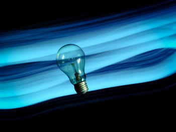 Close-up of light bulb against black background