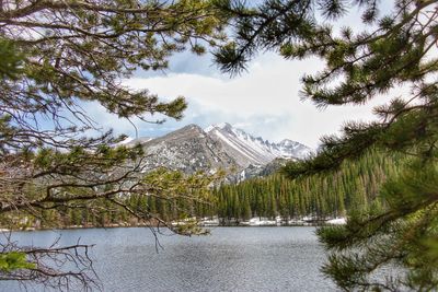 Scenic view of lake by snowcapped mountains against sky