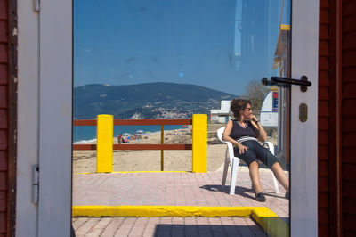 Side view of teenage boy against buildings