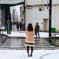 Rear view of people walking on wet street