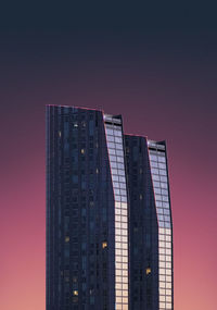 Low angle view of modern building against sky at dusk