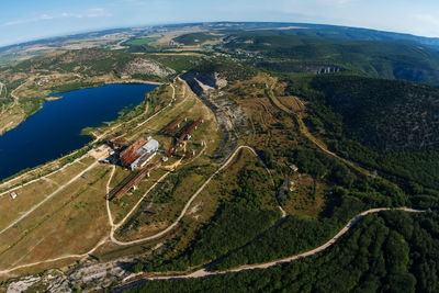 Top view of the lake and forests, dirt roads. on a sunny summer day with