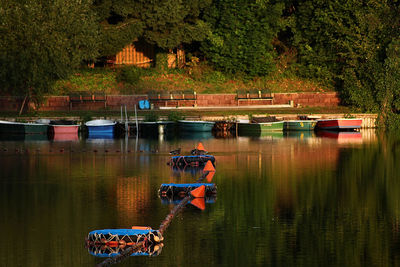 People in boat on lake against trees