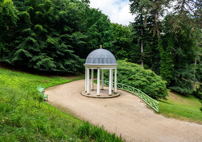 Gazebo on footpath in park against sky