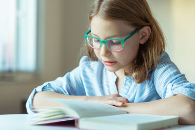 Cute girl reading book at home