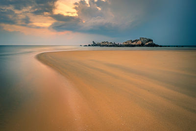 Scenic view of beach against sky during sunset