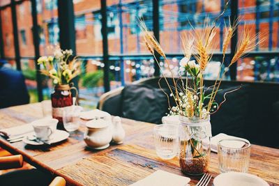 Flowers in glass vase on wooden table at cafe