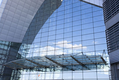 Low angle view of modern glass building against sky