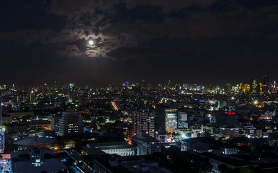 Illuminated cityscape against sky at night