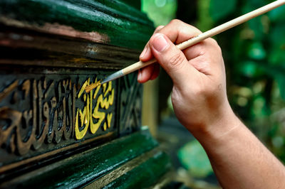 Close-up of hand holding painting