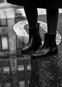 Low section of man standing on puddle