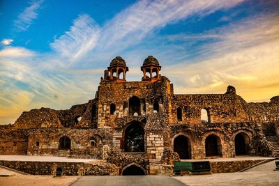 Low angle view of historical building against cloudy sky