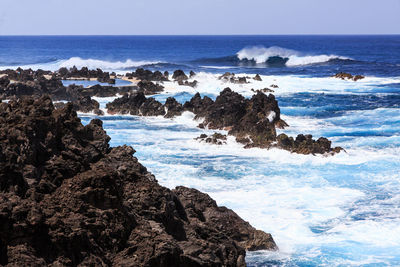 Scenic view of rocks in sea against sky