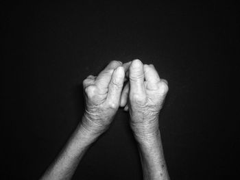 Close-up of human hands over black background