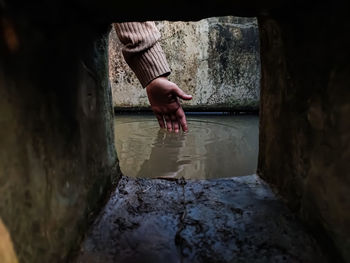 The reflection of a girl's hand fellon a water-filled cistern.