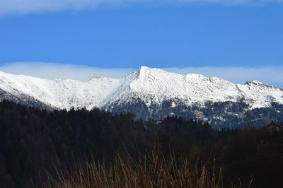 Scenic view of snowcapped mountains against blue sky