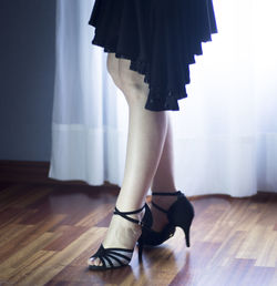 Low section of woman standing on hardwood floor