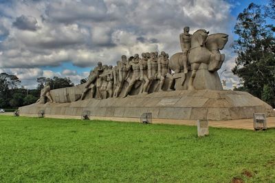 View of statue on field against cloudy sky