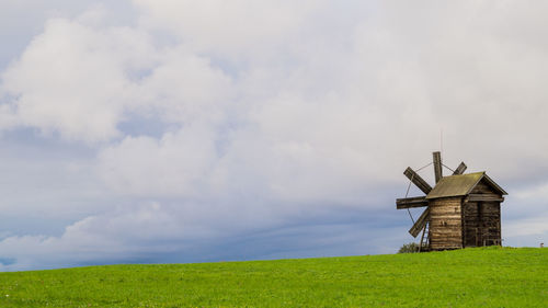 Traditional windmill on field against sky