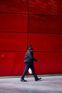 Full length of man standing against wall