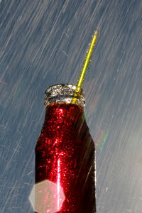 Close-up of water drops on bottle against gray background