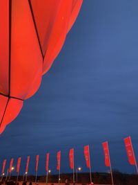 Low angle view of red balloons against sky at dusk