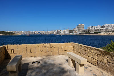 Buildings in city against clear blue sky