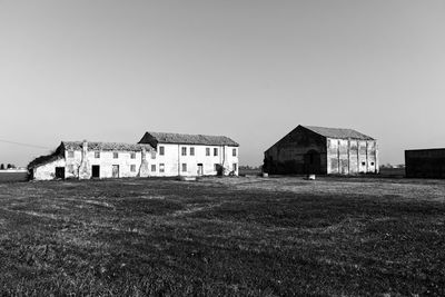 Houses on field against clear sky