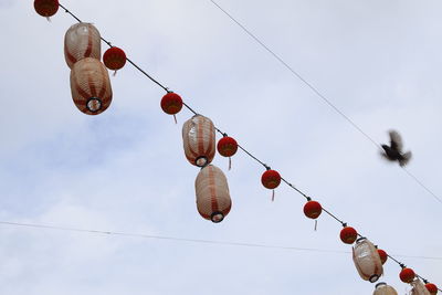 Low angle view of lanterns hanging against sky