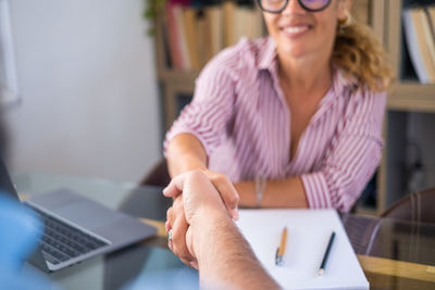 Portrait of woman using laptop while sitting on table