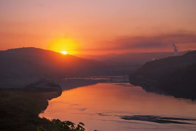 Scenic view of river against orange sky