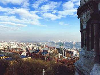 Aerial view of city against cloudy sky